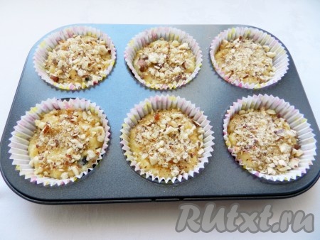 Тесто для черничных маффинов разложить по формочкам для выпечки на 1/3, сверху посыпать ореховой посыпкой.
