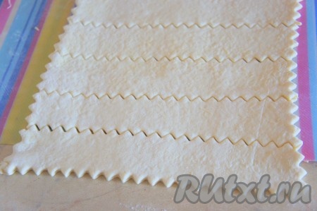 Тесто снова раскатать, чтобы сыр оказался в тесте. Разрезаь тесто на полоски.