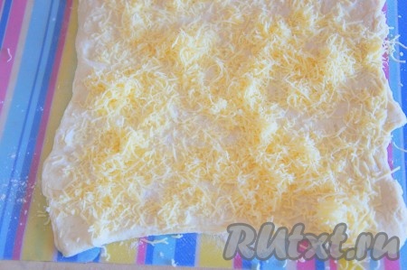 Тщательно посыпать тёртым сыром тесто по всему периметру.