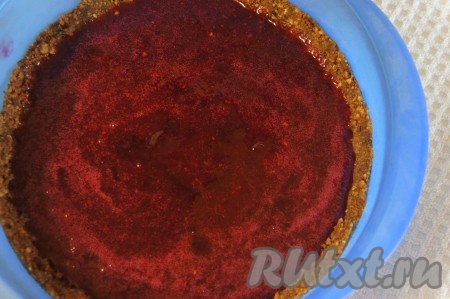 К протёртой с сахаром клюкве добавить набухший желатин и нагреть на среднем огне, но (!) не кипятить, при постоянном помешивании до растворения желатина, снять с огня. Как только клюквенная масса начнёт "схватываться", распределить её по всей поверхности коржа и убрать торт в холодильник, как минимум, на 60 минут (до полного застывания клюквенного слоя).