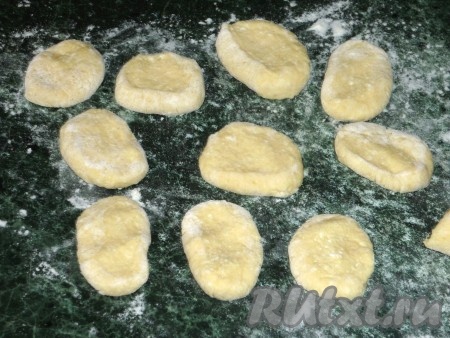 Каждый получившийся кусочек теста, повернув его срезом вверх, прижать слегка пальцами, получится небольшая лепёшка, в центре которой сделать пальцами небольшое углубление. Такая вмятинка на готовом ленивом варенике позволит ему лучше удерживать масло или сметану.