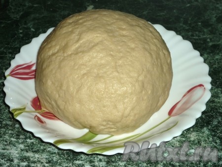 Если вишня заморожена, её нужно разморозить, выделившуюся жидкость слить. Свежие ягоды вымыть, удалить из них косточки. 500 грамм подготовленной вишни без косточек смешать с 50 граммами сахара, перемешать, поставить в холодильник на 1,5-2 часа, затем выложить на дуршлаг, чтобы стёк лишний сок. Для замешивания теста нужно сливочное масло комнатной температуры взбить миксером со сметаной, добавить сахар, соль, соду, погашенную уксусом. В получившуюся смесь постепенно добавить муку, замешивая мягкое, не липнущее к рукам тесто.