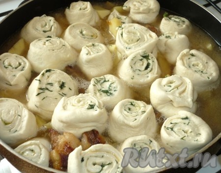 После того как мясо с картофелем протушатся с момента закипания 10 минут, выкладываем кусочки теста (штрудли) срезом вверх по всему периметру сковороды неплотно друг к другу, так как тесто под воздействием температуры разбухнет. Доливаем столько горячей воды, чтобы штрудли находились в ней по "пояс".