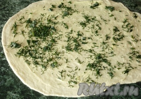 Замешанное тесто на присыпанной мукой поверхности раскатываем в достаточно тонкий пласт. Смазываем его сливочным маслом комнатной температуры, посыпаем мелко нарезанным укропом.