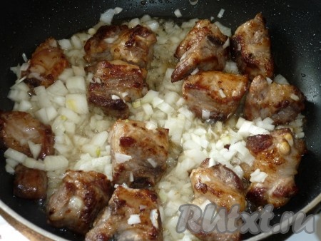 Лук очищаем, нарезаем мелко, выкладываем к мясу, обжаренному до румяности, перемешиваем, уменьшаем огонь до среднего.