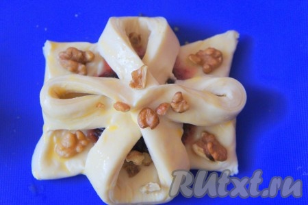 Орехи порубить ножом, украсить ими слойки с вареньем.
