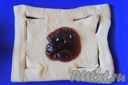 Тесто разрезать на квадраты (я использовала покупное слоеное тесто и тесто не раскатывала, если вы используете тесто собственного приготовления, то раскатать его нужно толщиной 0,5 см). Сделать надрезы около каждого угла, как показано на фото, а в самый центр положить варенье (на 1 слойку - 1 столовую ложку).
