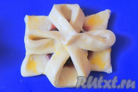 Слойки выложить на застеленный силиконовым ковриком или пергаментной бумагой противень и смазать взбитым яйцом (удобно использовать для этого кондитерскую кисть).
