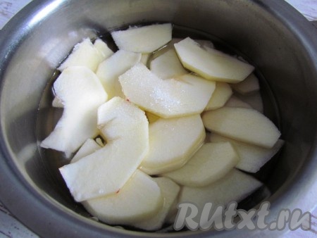 Сахар растворить в воде, перелить сладкую воду в сотейник и поставить на средний огонь. Туда же добавить яблочные ломтики.