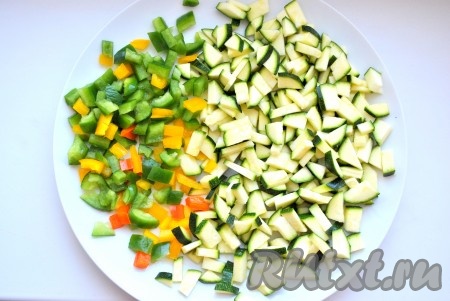 Болгарский перец и цуккини нарезать кубиками, обжарить на растительном масле около 10 минут, затем добавить измельченные помидоры и тушить до готовности (еще около 10-15 минут), посолить, поперчить.
