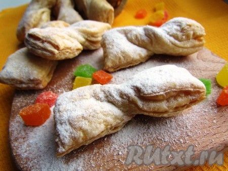 Выпекать печенье до румяной корочки около 15 минут при температуре 190-200 градусов. Готовое печенье "бантики" посыпать сахарной пудрой.
