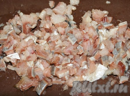 Селёдку разделать на 2 филе, удалить кожу, все кости и хорошо промыть. Филе нарезать на мелкие кубики.