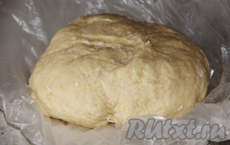 С лимона снять цедру. Муку смешать с разрыхлителем и лимонной цедрой. В отдельной миске смешать растопленное сливочное масло, яйцо и сметану. Добавить муку в миску со сливочным маслом. Замесить тесто, постепенно добавляя сок половины лимона. Тесто должно получиться нежным и эластичным. Полученное тесто положить в пакет и отправить в холодильник на 30 минут.
