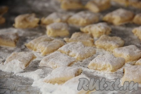 Отдохнувшее тесто достать из холодильника и раскатать в пласт толщиной в 1 см, нарезать тесто на квадратики размером в 2х2 см.
