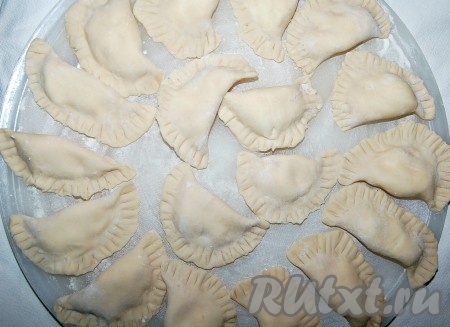 Готовые сырые варенички с творогом складываем на доске, посыпанной небольшим количеством муки, чтобы не прилипли к ней.
