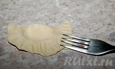 Аккуратно лепим вареник с творогом, при этом стараемся сделать края как можно тоньше, чтобы вареники получились нежными, без грубых толстых швов.&nbsp; Самый простой вариант обработки краев вареников - обработать их с помощью вилки.
