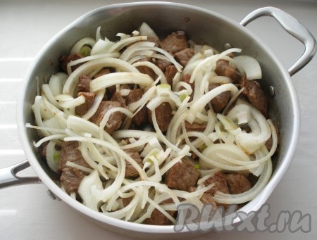 Выложить к мясу лук, перемешать и обжарить все вместе.