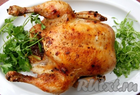 Запекать цыпленка, примерно, 1 час 20 минут в разогретой духовке. Затем можно пробовать мясо на готовность: проткнуть тушку вилкой в районе бедра, если вытекает прозрачный сок, значит мясо готово. Переложить запечённого в духовке цыпленка на блюдо, добавить зелени и подавать на стол.