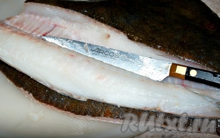 С помощью острого ножа отделить одно филе от кожи и костей.