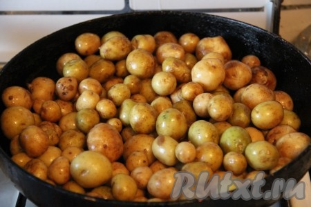 На горячую сковороду добавить растительное масло, нагреть его и высыпать картофель, посолить слегка солью (солью солим слегка, так как её мы будем использовать в два этапа). Сковороду закрыть крышкой и не открывать её до конца приготовления. Так как картофель молодой и мелкий, перемешивать мы его будем прямо под крышкой. Взявшись за ручку сковороды и за крышку, мы хорошенько трясем сковородку, чтобы картофель равномерно перемешался. Таким образом жарим картошку на небольшом огне до конца приготовления, не открывая крышку. Время приготовления зависит от размеров молодого картофеля, обычно на жарку у меня уходит 20-30 минут.