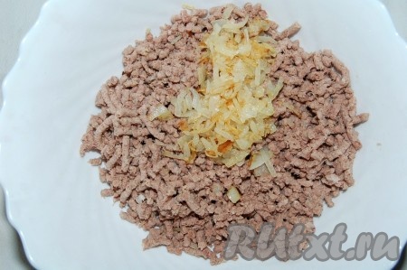 Вареное мясо пропустить через мясорубку. Полученный фарш сложить в миску и добавить к нему обжаренный репчатый лук.