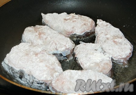 В сковороду налить растительное масло, раскалить его и в раскалённое масло выложить подготовленные стейки из зубатки.