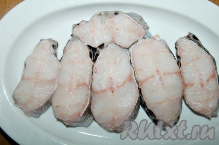 Хвостовую часть зубатки нарезать на стейки. Посолить их по вкусу.