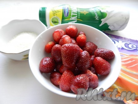 Подготовить продукты для приготовления желейного десерта с клубникой. Клубнику можно использовать как свежую, так и замороженную. Свежие ягоды нужно будет промыть водой, удаляя чашелистики, немного обсушить. Замороженную клубнику нужно будет немного разморозить. Сухое желе в пакетике я взяла, рассчитанное на 400 миллилитров жидкости (о том, на какое количество жидкости рассчитало сухое желе, написано на упаковке). Желе подойдёт с любым вкусом, у меня - апельсиновое.