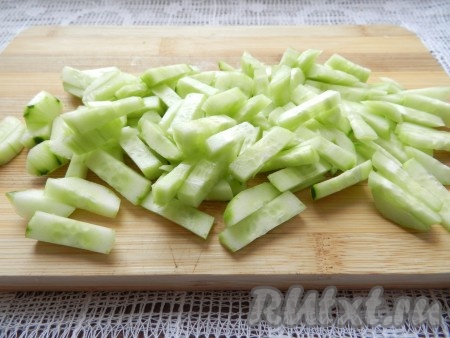 Вымытые свежие огурцы, по желанию, очистить от кожуры, а затем нарезать на небольшие брусочки.