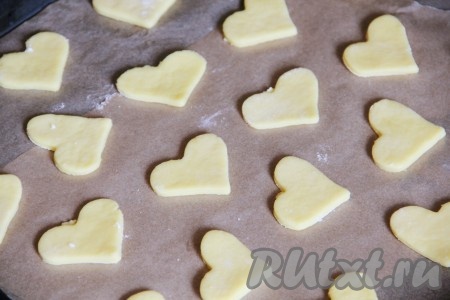 Рабочую поверхность посыпать мукой, тесто раскатать в пласт толщиной 5 мм, формочкой выдавить печенье и выложить его на противень, предварительно застеленный пергаментной бумагой.
