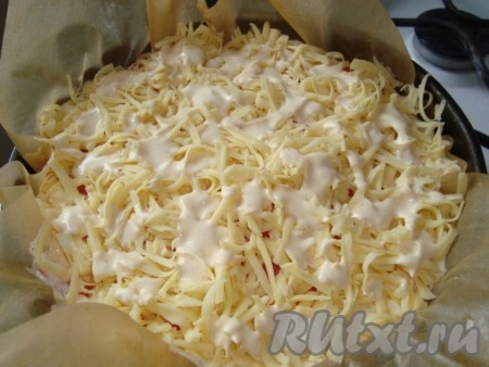 Сыр натереть на крупной терке, посыпать пирог, полить оставшимся соусом.
