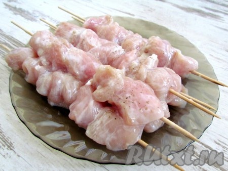 Деревянные шпажки смочите холодной водой и нанижите кусочки замаринованного куриного мяса.