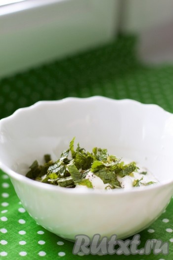 Приготовьте соус к оладьям. Смешайте мяту, цедру лимона (по желанию) и сметану. Приправьте перцем.