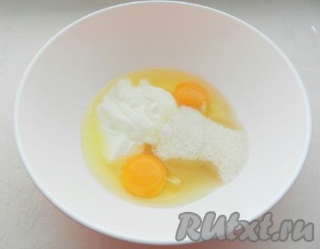 В глубокой миске смешать венчиком яйца с сахаром, солью и сметаной до однородности.