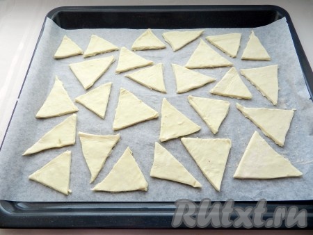 Слоеное дрожжевое тесто разморозить. С помощью формочек или произвольно вырезать будущее печенье. Выложить на противень, застеленный бумагой.
