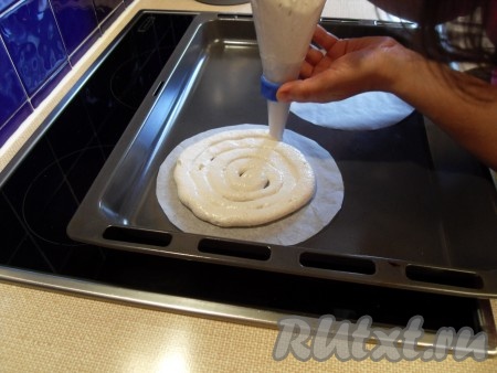 Вырезать из пекарской бумаги три круга диаметром 18 см. Положить их на лист и отсадить на них наше “тесто” в виде спирали с помощью кондитерского мешочка с круглой насадкой диаметром 1 см.