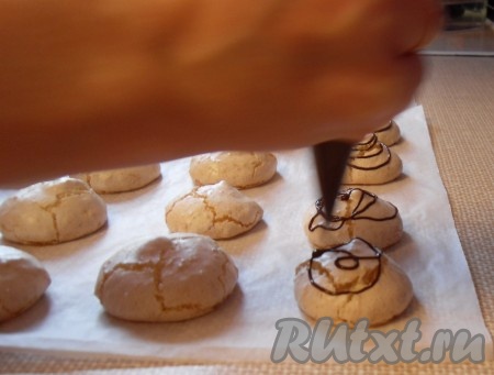 Шоколад вылить в кондитерский мешок и отрезать кончик. Полить безе с кокосовой стружкой шоколадом и оставить остывать. Если нужно чтобы шоколад застыл быстро, можно выложить безе в один слой на большую тарелку и поставить в холодильник на 10 минут.