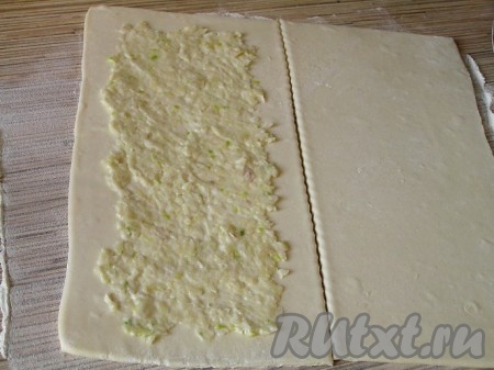 Слоеное тесто раскатать, разрезать на прямоугольники. Смазать чесночной пастой.