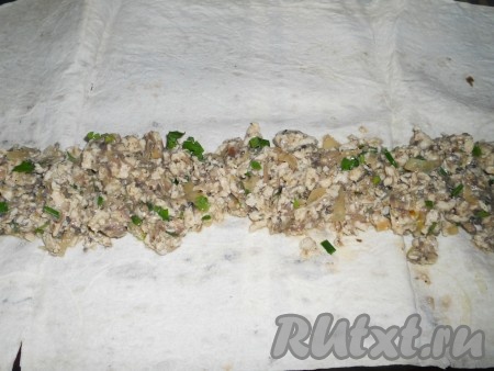 Раскладываем на поверхности лаваш, выкладываем на него начинку во всю длину (которая длиннее).
