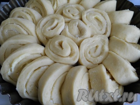 Сворачиваем в рулеты (у нас получается 2 рулета). Каждый рулет режем на кусочки шириной 2-3 см.

Форму (круглую) смазываем маслом и выкладываем кусочки рулетов по кругу, до половины захватывая один другим.