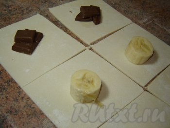 На припылённом мукой столе раскатайте тесто до толщины примерно 2 миллиметра. Разрежьте ножом тесто на квадратики со стороной 5 сантиметров. В середину каждого квадрата выложите начинку, например, по 2-3 кусочка шоколада или по небольшому кусочку банана. Так как банан был спелый, я сахар в банановые конвертики не добавляла.