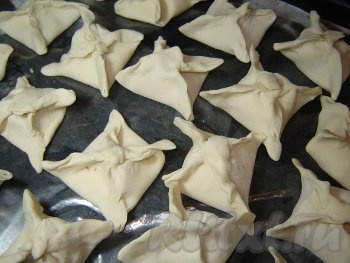 Аккуратно соедините противоположные углы каждого квадрата из теста над начинкой так, чтобы получился "запечатанный конвертик" из слоёного теста с начинкой внутри. Добросовестно "запечатывайте" каждый конвертик, не оставляйте разрывов, иначе в духовке конвертики развернутся.