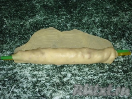 При помощи тонкой палочки (я использовала 2 трубочки для сока) свернуть тесто в рулет таким образом, чтобы сверху оказалось тесто, непокрытое начинкой.
