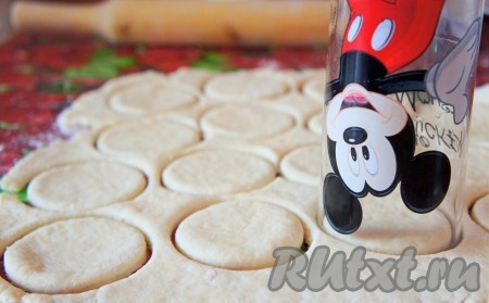 Рабочую поверхность посыпать мукой, выложить тесто. Тесто необходимо раскатать толщиной 0,5 см, с помощью стакана сделать "заготовки" (кружки) для печенья.
