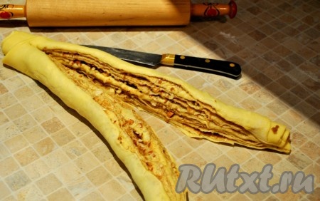 Рулет разрезать ножом вдоль, но не до самого конца (оставить приблизительно 2 см) и скрутить (сплести как косу, но только из двух частей), затем соединить концы.
