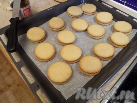 Одну половинку печенья смазать сгущенкой, приклеить вторую половинку.