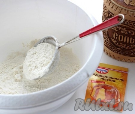 Сливочное масло для приготовления пирога должно быть мягким, поэтому его нужно заранее достать из холодильника, чтобы оно немного полежало при комнатной температуре. В миску просеять муку, разрыхлитель и соль, перемешать мучную смесь.