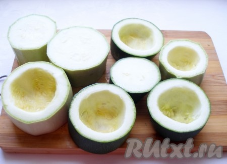 Нарезать кабачки на части высотой около 3-4 см. Чайной ложкой выбрать мякоть, сделав своеобразные стаканчики (как на фото). Кабачки сложить в кастрюлю, залить водой и отварить до полуготовности, немного посолив воду. В зависимости от размера кабачков варить 3-5 минут после закипания. Затем жидкость слить, кабачки остудить.
