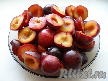 Разрезать сливы пополам, вынуть косточки.