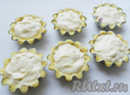 Поверх фруктов и ягод песочные корзиночки заполнить творожной заливкой.